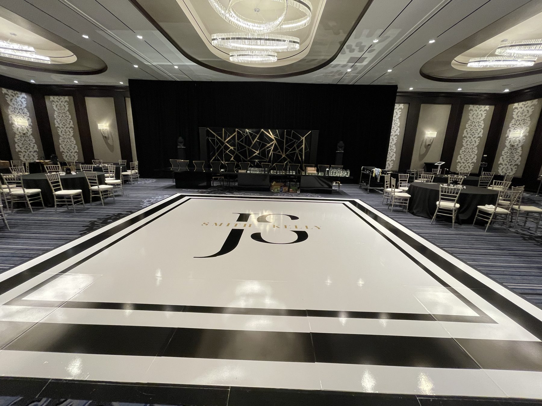 White dance floor wrap with a bold black border and black monogram in a modern ballroom at the Kimpton Tryon Park Hotel, Charlotte